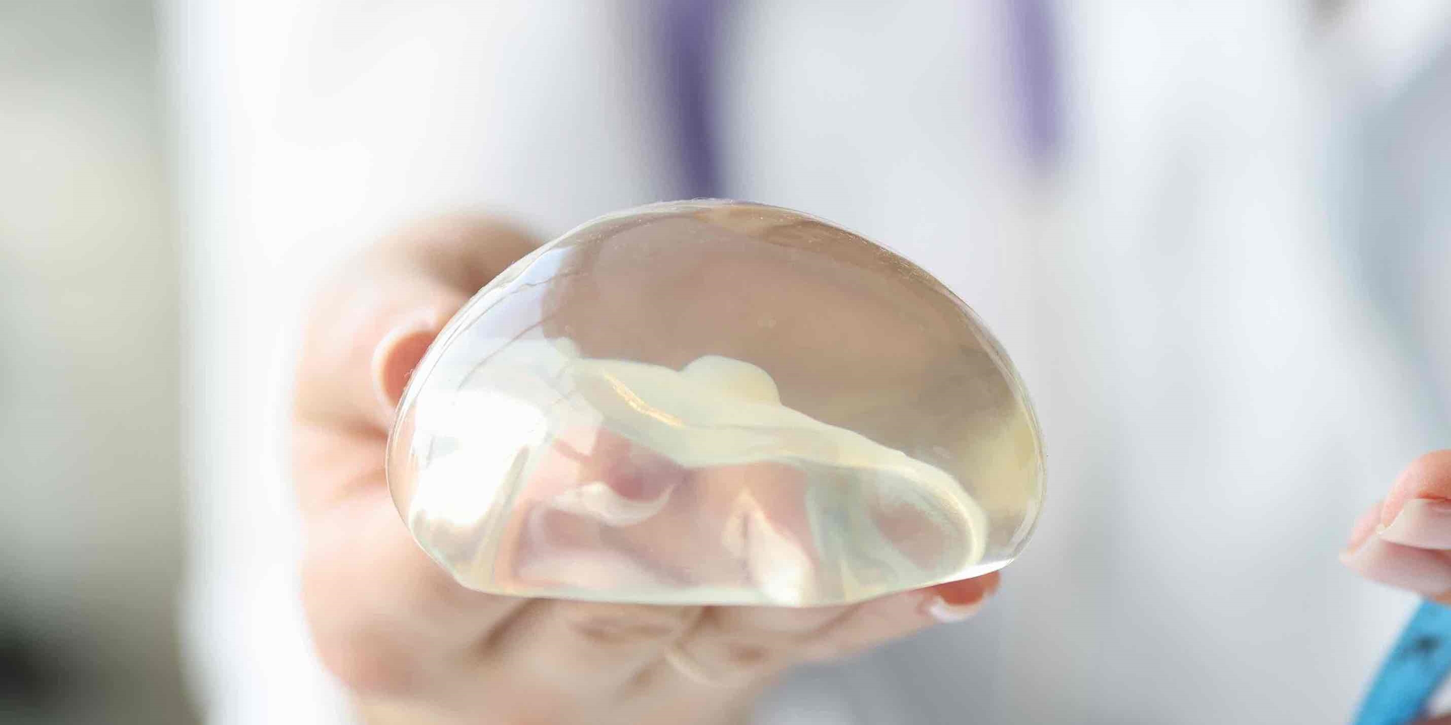 Woman holding breast implant Woman holding breast implant